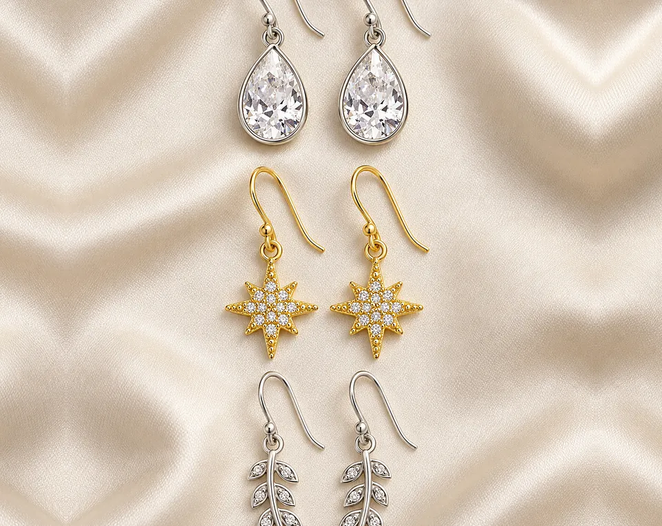 Silver and gold plated drop earrings on champagne satin