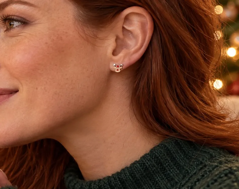A model wearing a small character earring in warm festive light